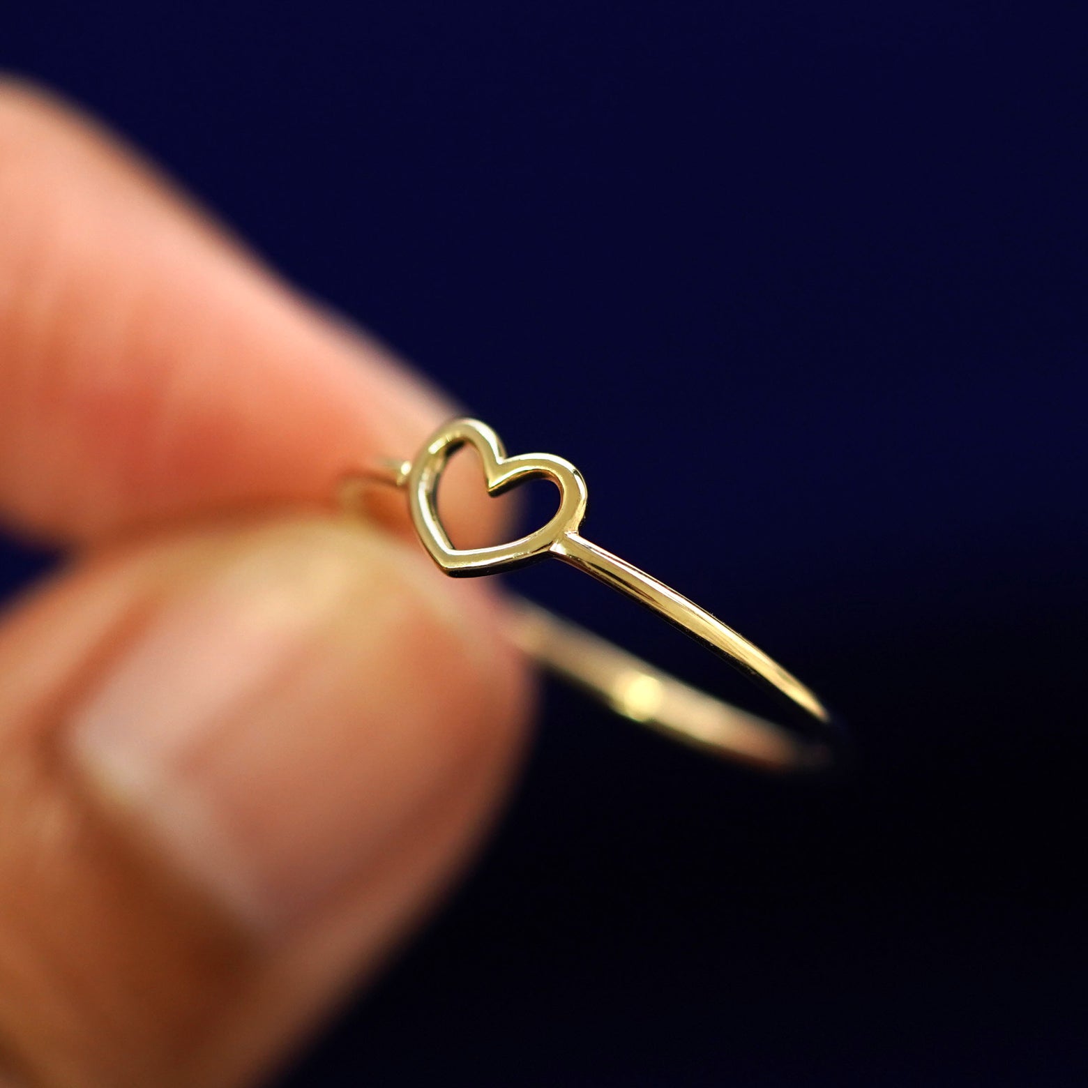 A model holding a Heart Ring tilted to show the side of the ring