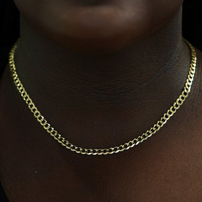 A model's neck wearing a solid 14k gold Curb Chain