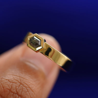 A model holding a Hexagon Diamond Band tilted to show the side of the ring
