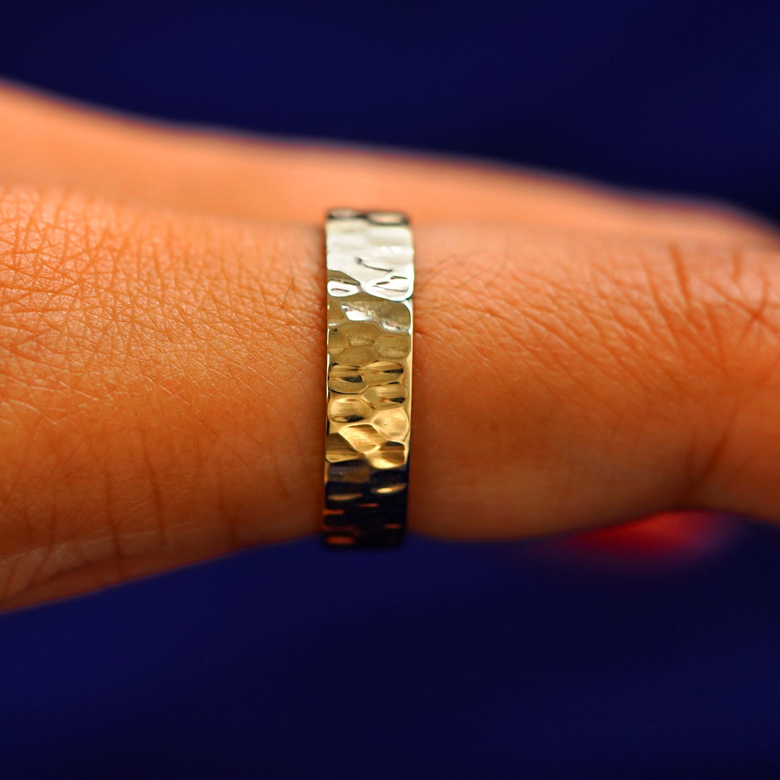 Side view of a Industrial Hammered Band on a model's finger