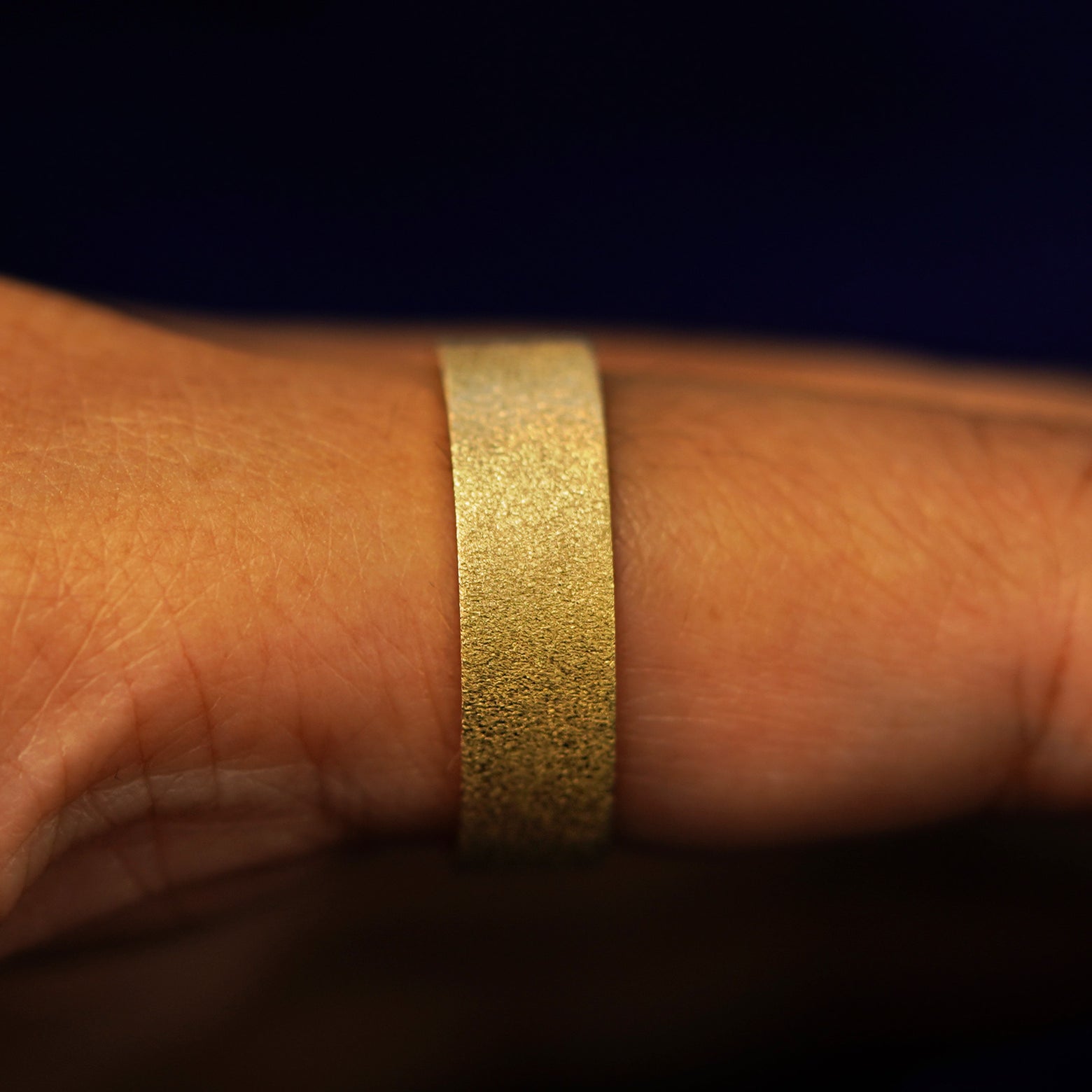Side view of a Industrial Stardust Band on a model's finger