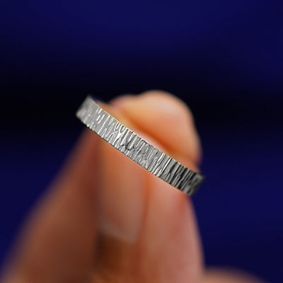 A model holding a Platinum Industrial Wood Band tilted to show the details of the wood finish