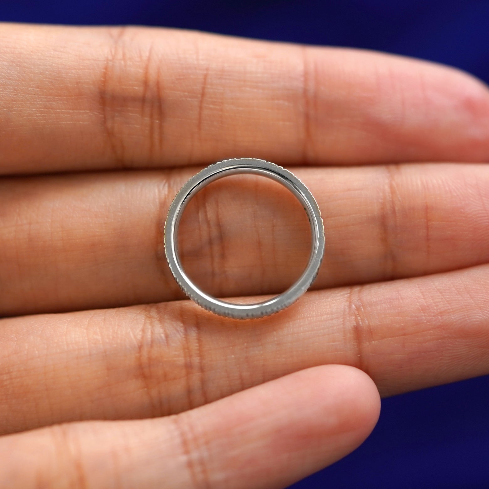 A Platinum Industrial Wood Band resting on a model's fingers to show the thickness of the band