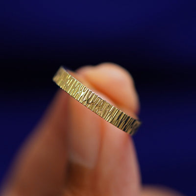 A model holding a Industrial Wood Band tilted to show the side of the ring