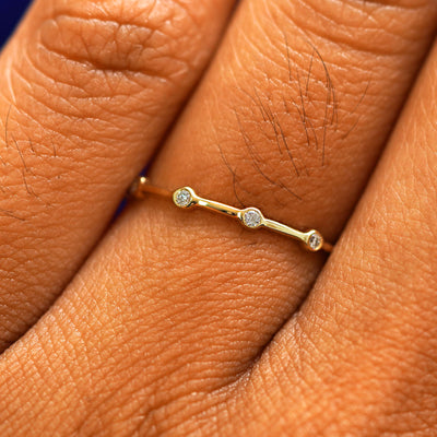 Close up view of a model's fingers wearing a 14k yellow gold Spaced Infinity Ring