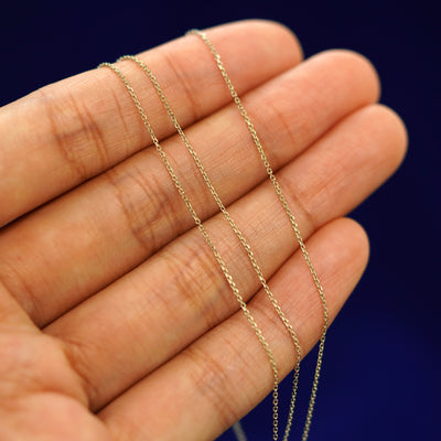 A model's hand holding a Cable Infinity chain wrapped loosely around their fingers 3 times