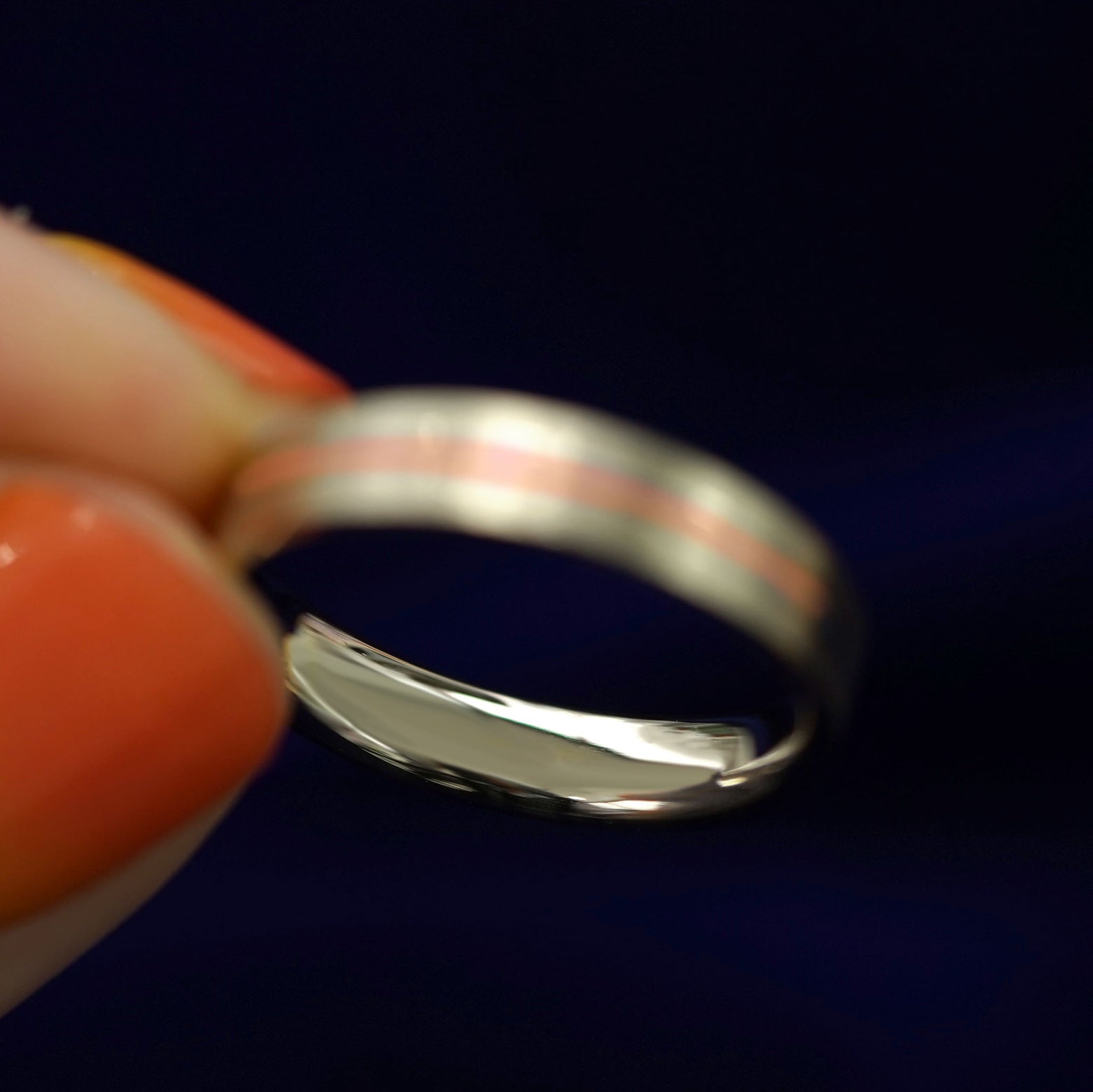 A model holding an Inlay Band to show the inside of the ring