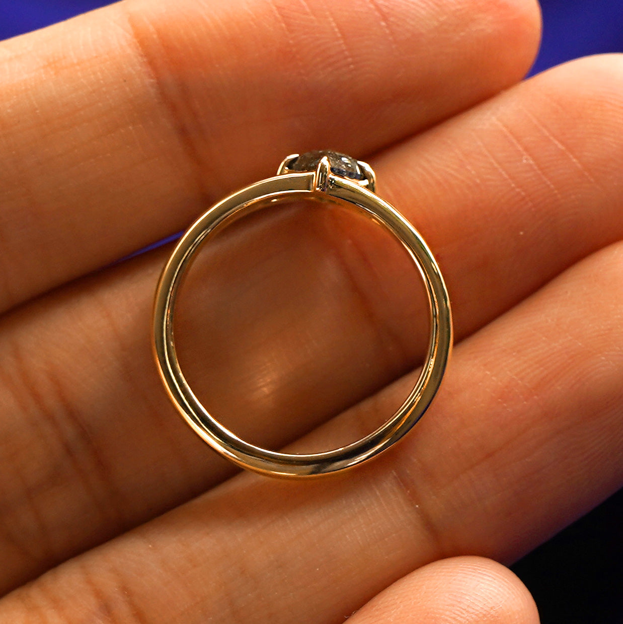 A Diamond Kite Ring in a model's hand showing the thickness of the band and the height of the ring