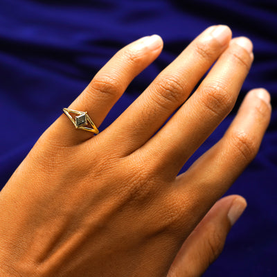 Close up view of a model's hand wearing a yellow gold Diamond Kite Ring on their pinky finger