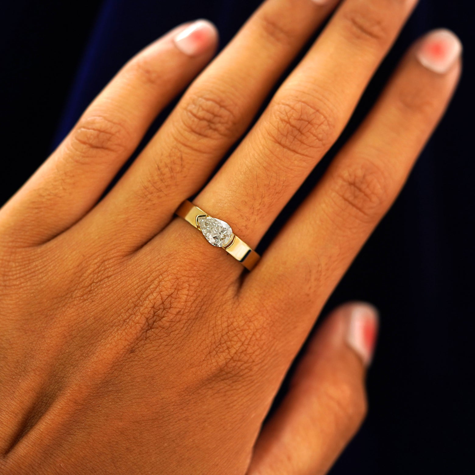 Close up view of a model's hand wearing a yellow gold Lab Diamond Pear Ring