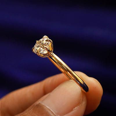 A model holding a Round Lab Diamond Ring tilted to show the inside of the ring