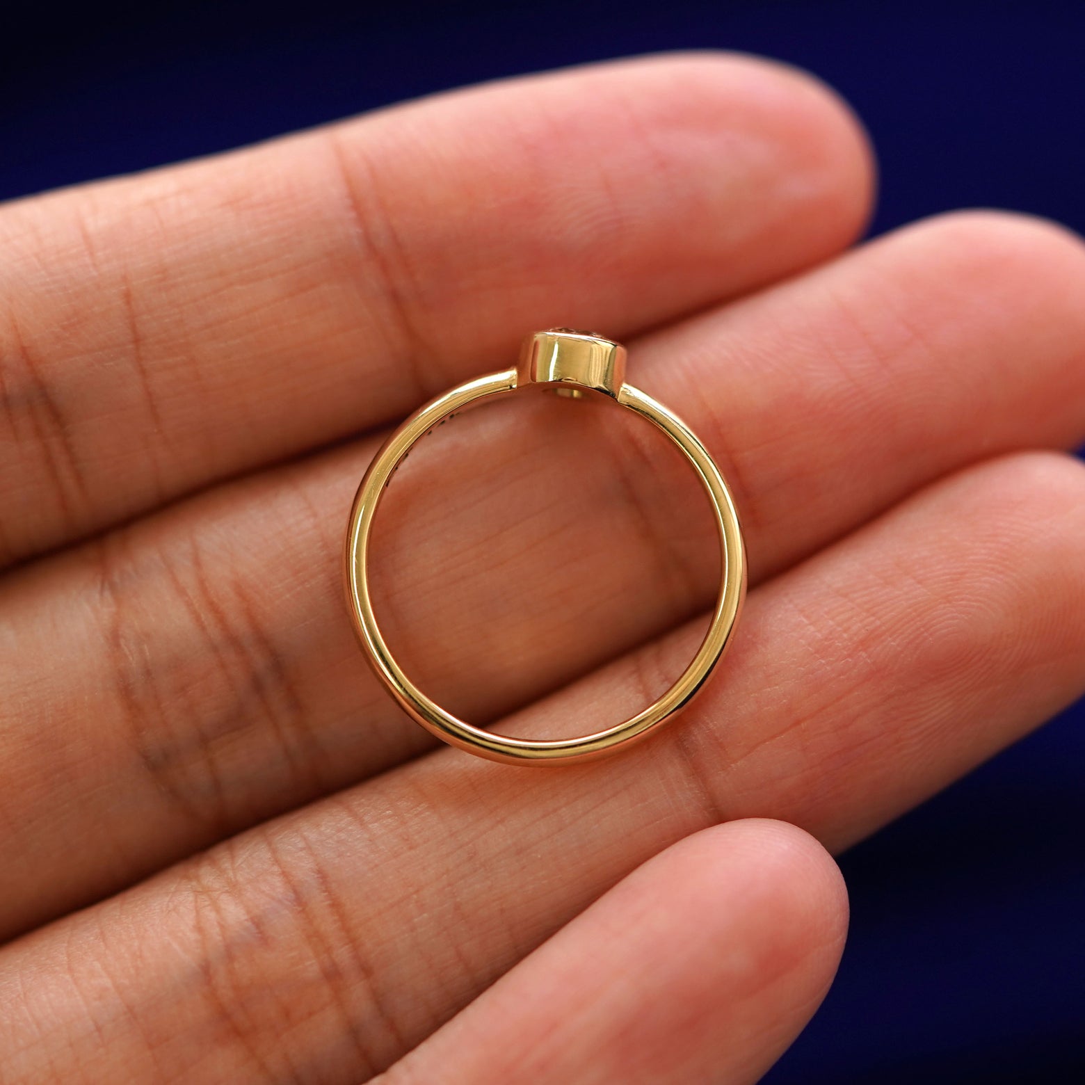 A yellow gold 1/3ct Diamond Ring in a model's hand showing the thickness of the band