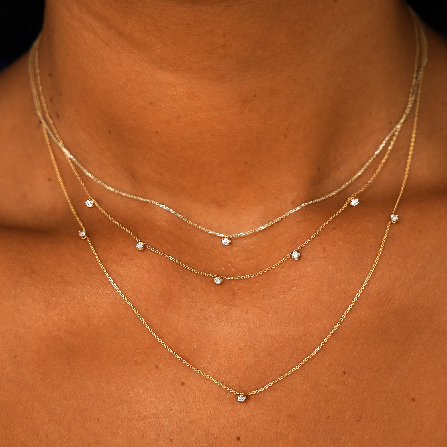A model wearing a Diamond Cable Necklace, a 5 Diamond Cable Necklace, and 3 Diamond Cable Necklace layered 