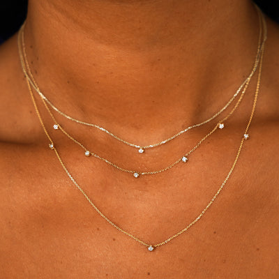 A model wearing a Diamond Cable Necklace, a 5 Diamond Cable Necklace, and 3 Diamond Cable Necklace layered 