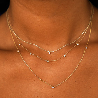 A model wearing a Diamond Cable Necklace, a 3 Diamond Cable Necklace, and 5 Diamond Cable Necklace layered