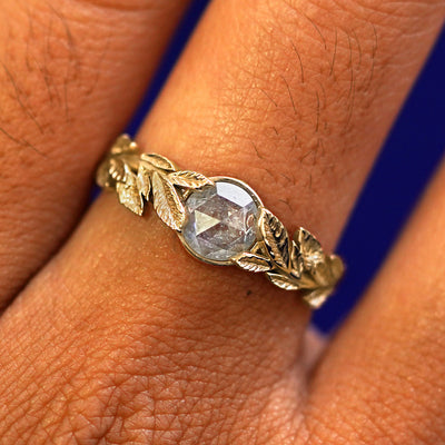 Close up view of a model's fingers wearing a 14k yellow gold Diamond Leaves Ring
