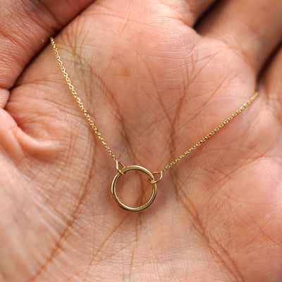 A yellow gold Lockless Cable Necklace draped on a model's palm