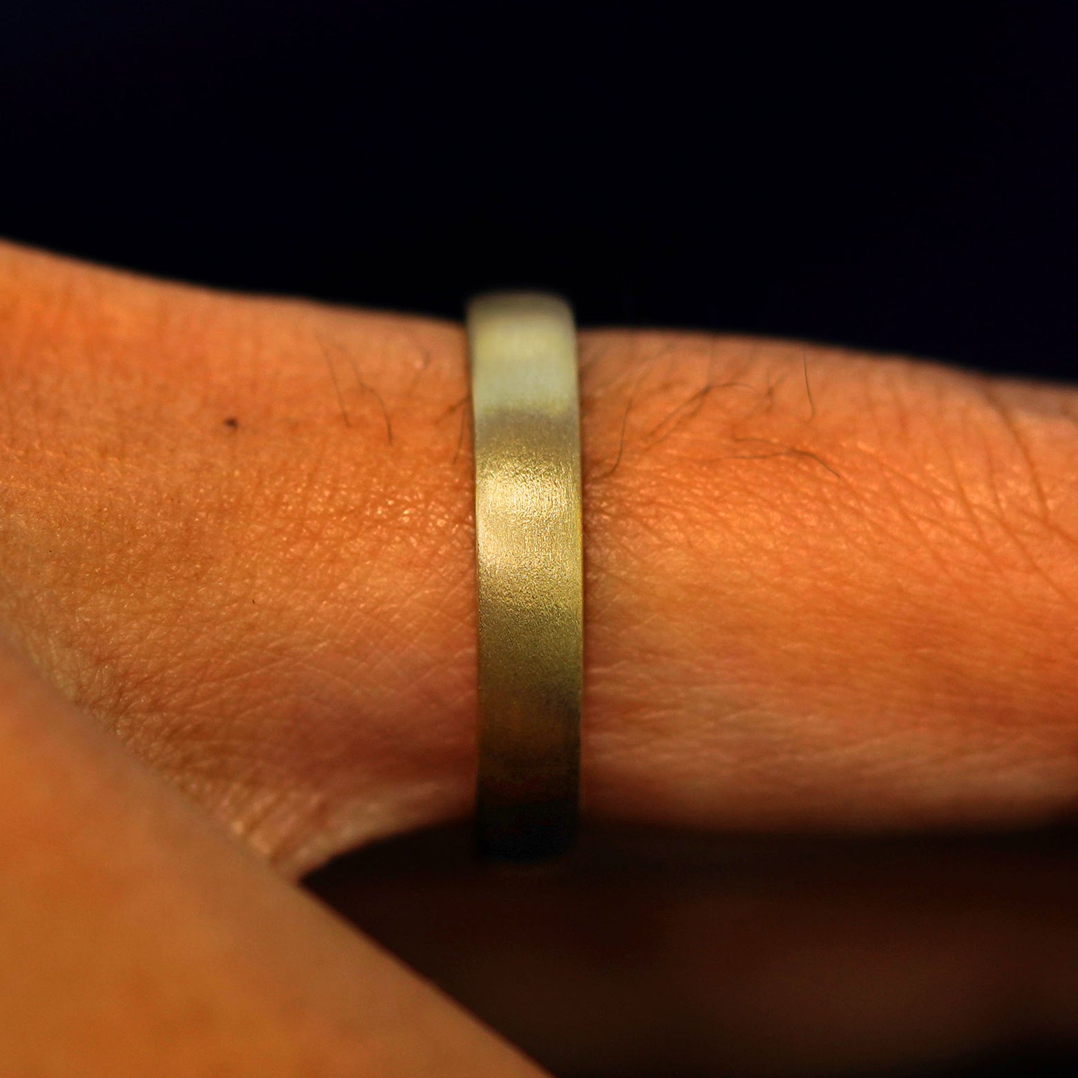 Side view of a 14 karat solid gold Mix Matte Band on a model's finger