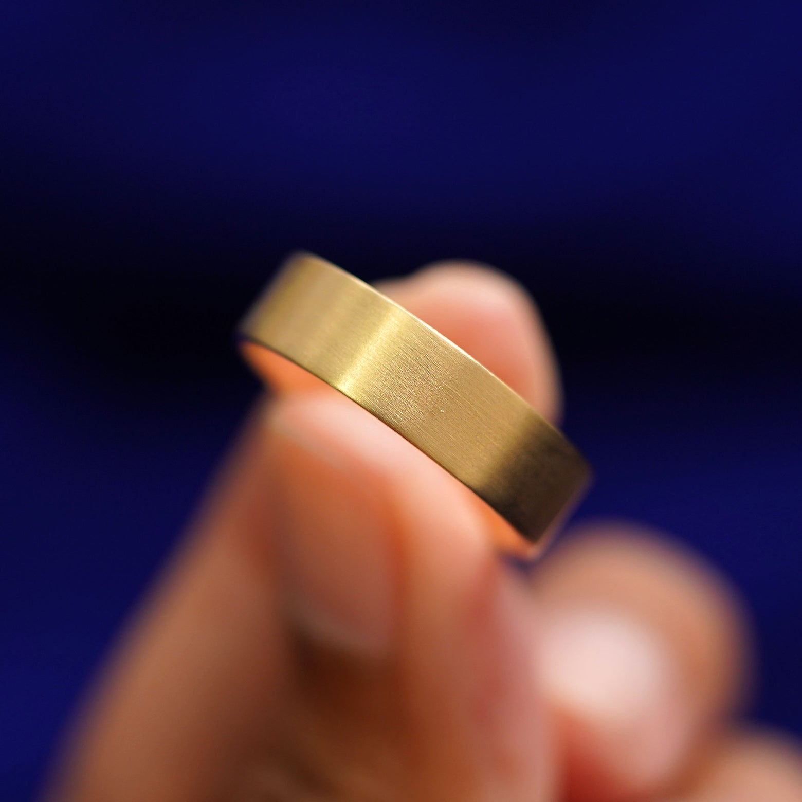 A model holding a Industrial Matte Band tilted to show the side of the ring