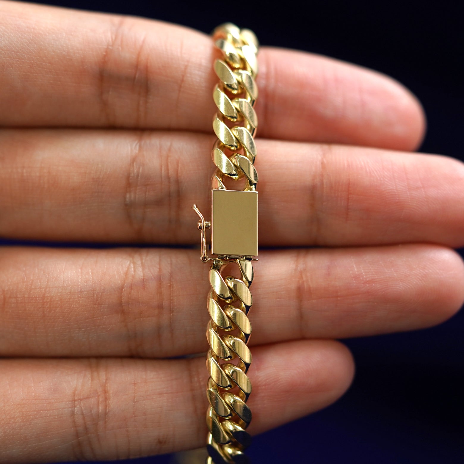 Close up view of a Box clasp with safety catch on a yellow gold Miami Cuban Chain