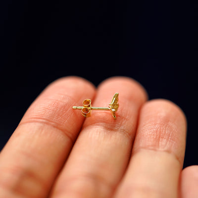 Side view of a Mini Butterfly Earring with a standard pushback backing sitting on a model's fingertips