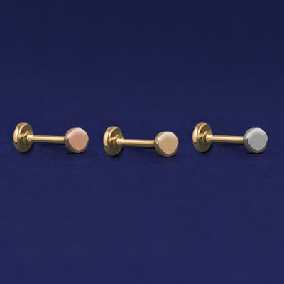 Three versions of the Mini Circle Flatback Piercing shown in options of rose, yellow, and white gold