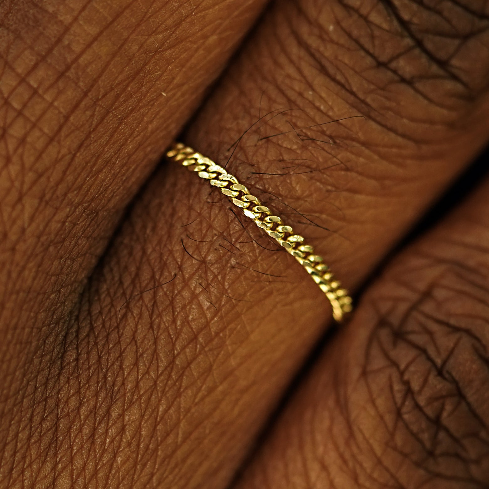 Close up view of a model's fingers wearing a 14k yellow gold Mini Miami Ring