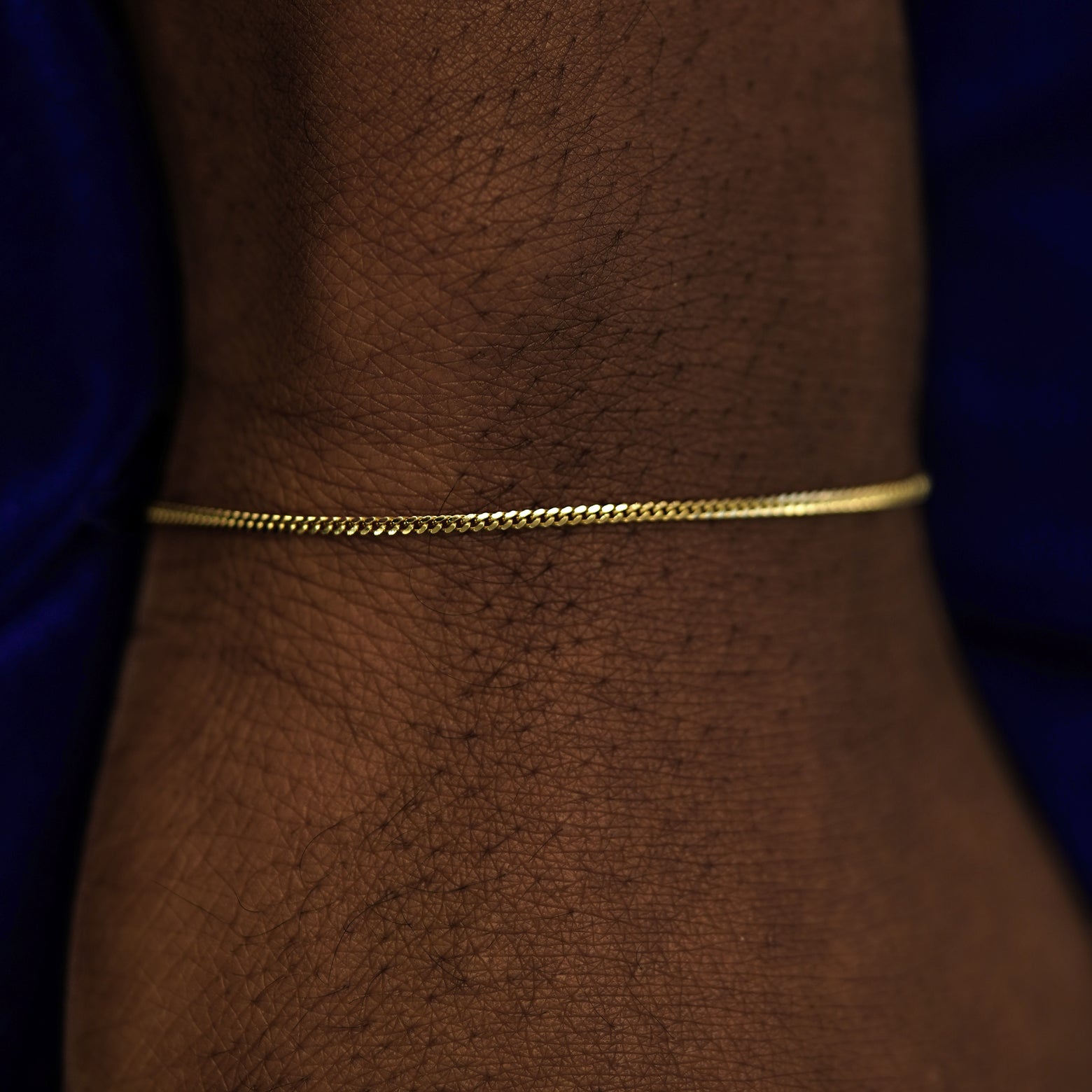 A model's wrist wearing a 14k yellow gold Mini Miami Bracelet