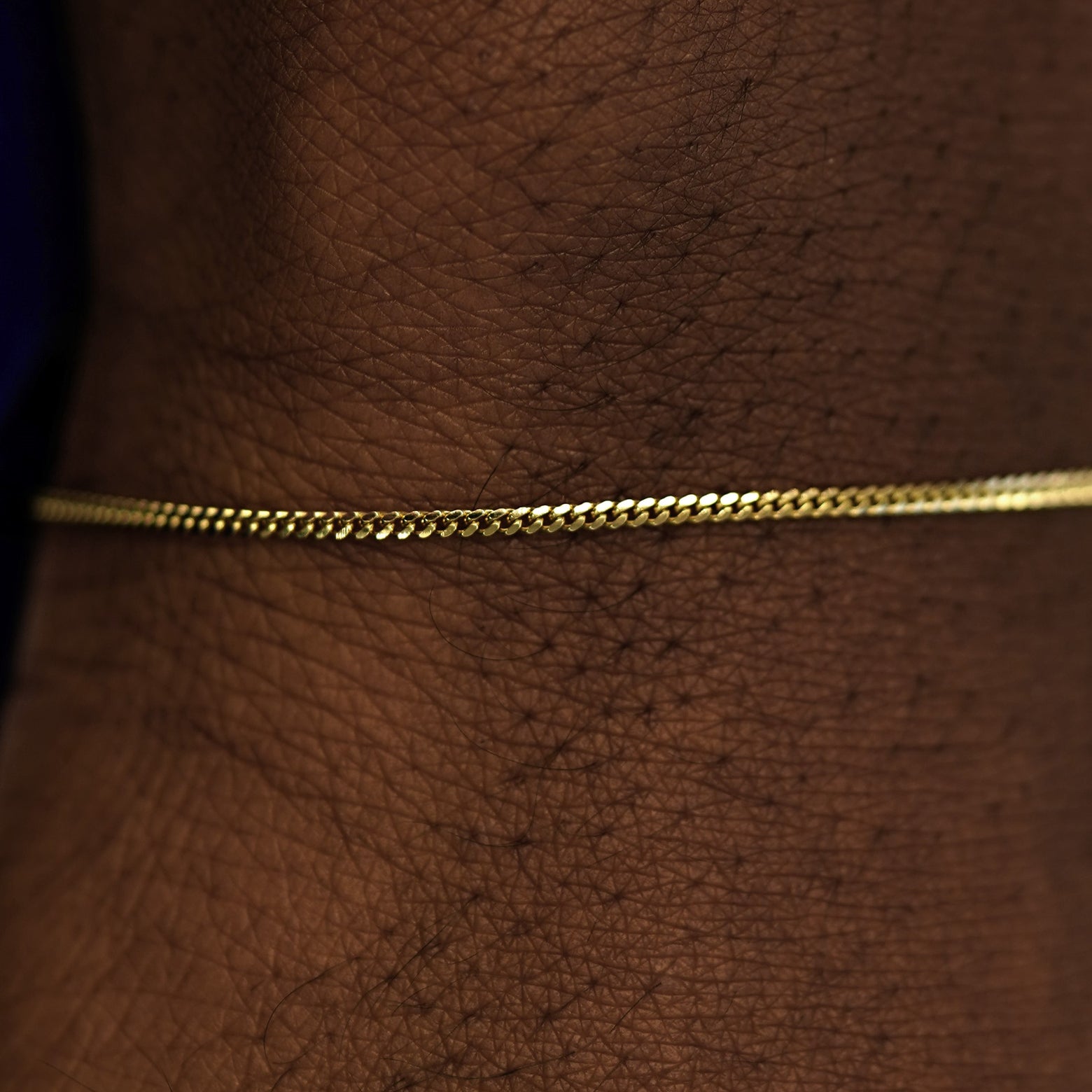 Close up view of a model's wrist wearing a 14k yellow gold Mini Miami Bracelet