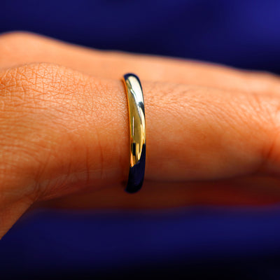 Side view of a Curvy Mirror Band on a model's finger