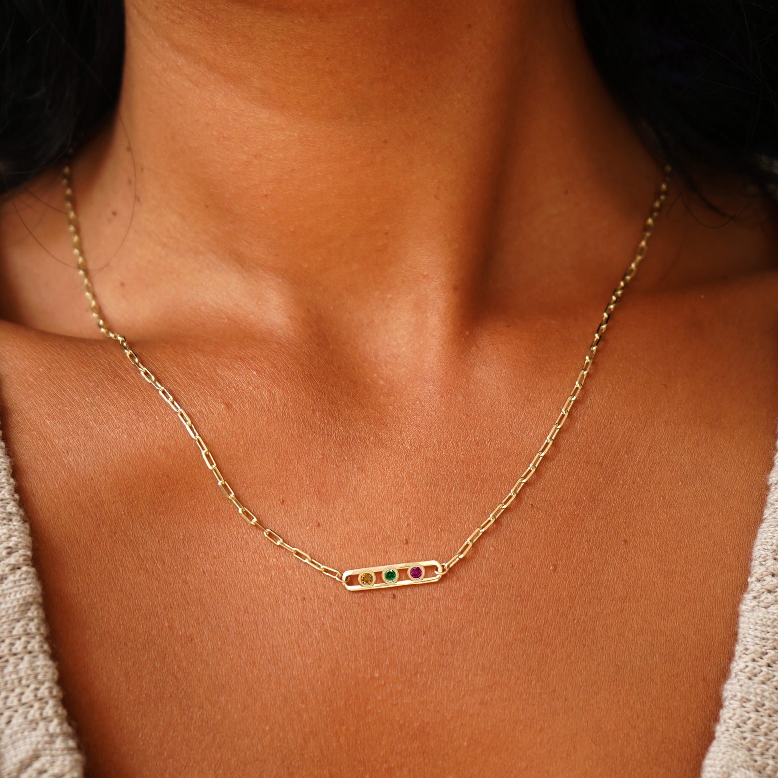 Close up view of a model's neck wearing a Dancing Gemstone Necklace with citrine, emerald, and ruby gems