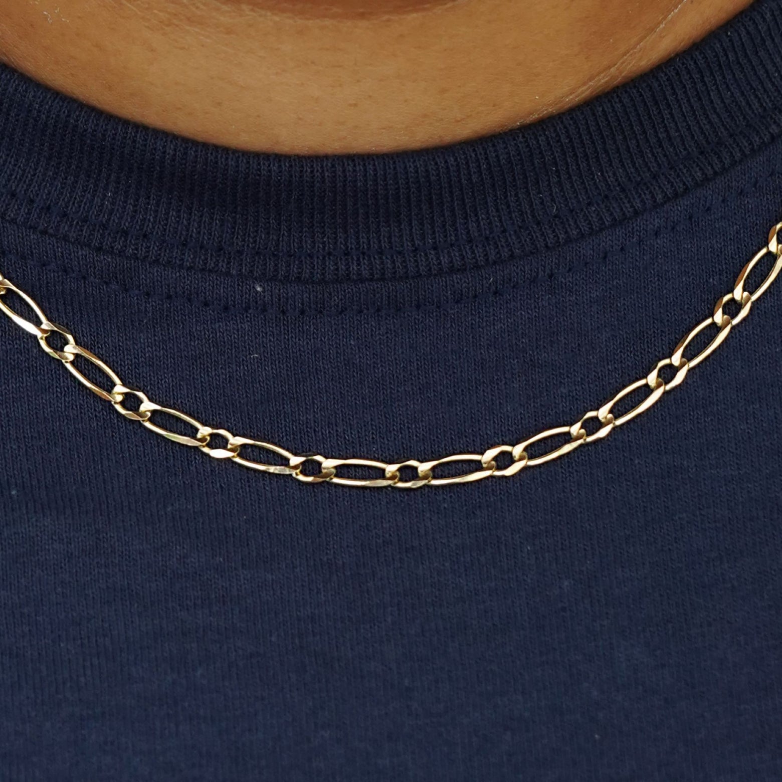 Close up view of a model's neck wearing a yellow gold One To One Chain