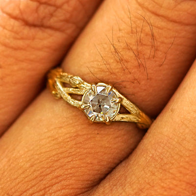 Close up view of a model's fingers wearing a 14k yellow gold Moissanite Branches Ring