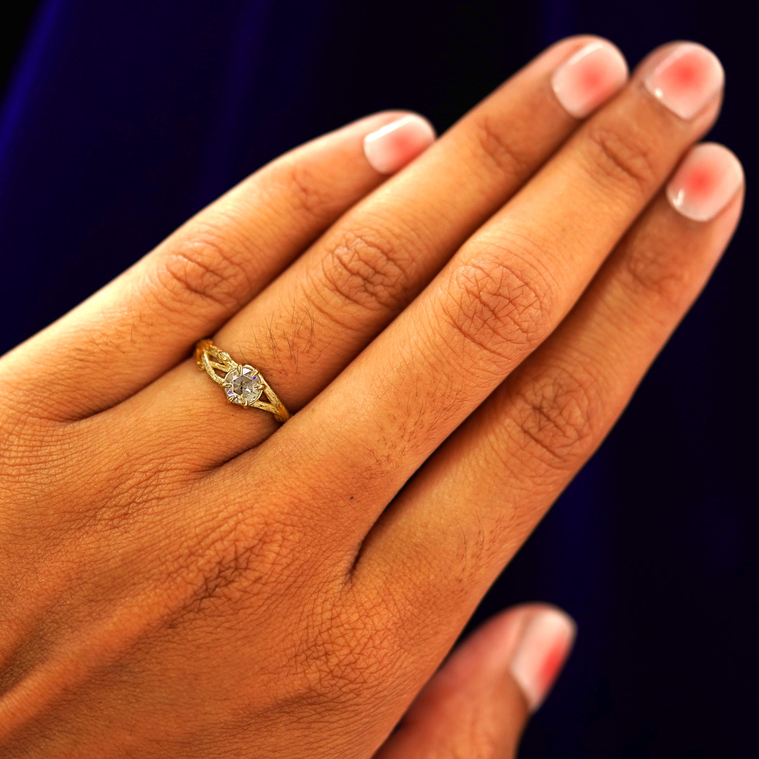 Close up view of a model's hand wearing a yellow gold Moissanite Branches Ring