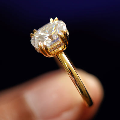 A model holding a Oval Moissanite Halo Ring tilted to show the details of the ring