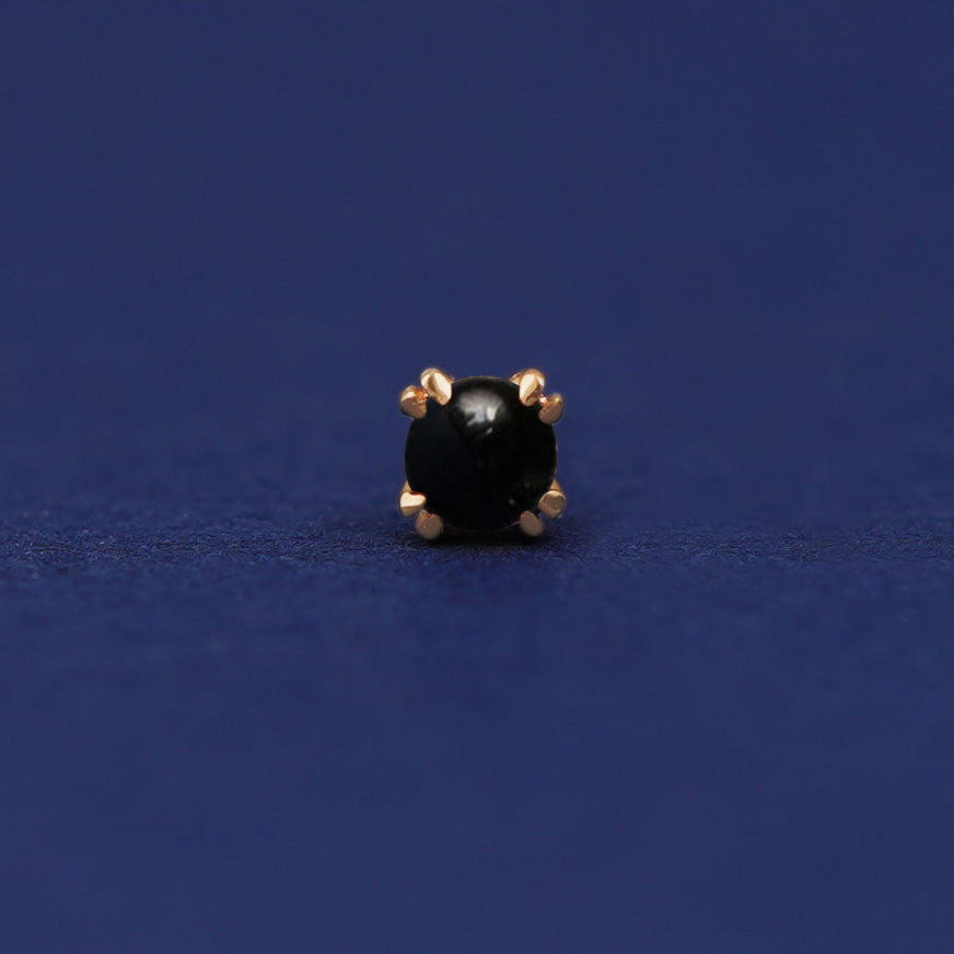 A 14 karat gold stud earring with 3 millimeter round Onyx gemstones