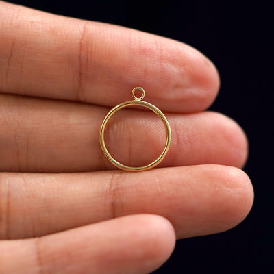 A solid 14k yellow gold Circle Jacket sitting in a model's palm