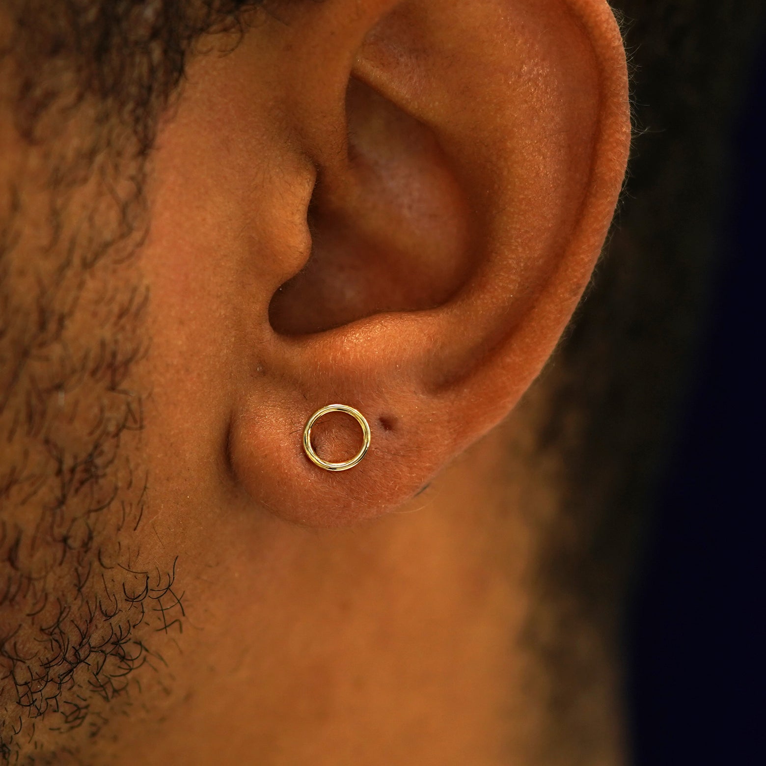 A model's ear wearing a 14k yellow gold Open Circle Earring
