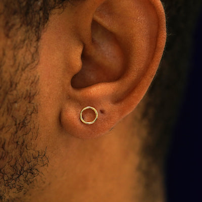 A model's ear wearing a 14k yellow gold Open Circle Earring