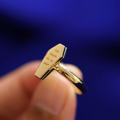 A model holding a Coffin Ring tilted to show the side of the ring