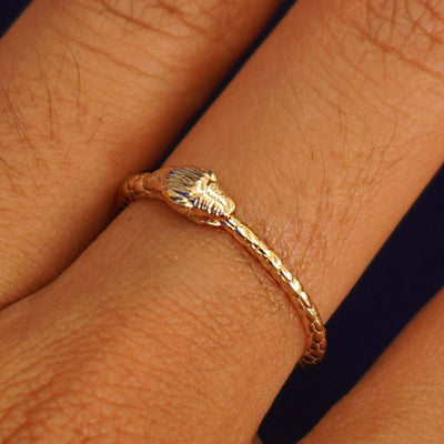 Close up view of a model's hand wearing a yellow gold Ouroboros Snake Ring
