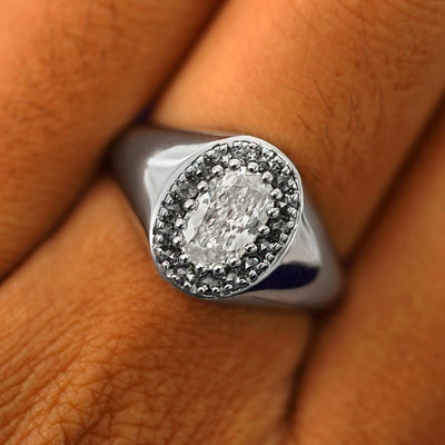 Close up view of a model's fingers wearing a 950 platinum Oval Diamond Signet Ring 