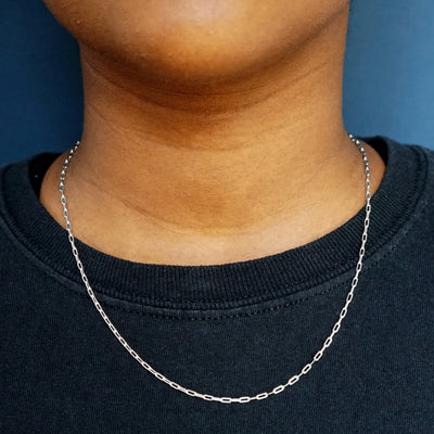 Close up view of a model wearing a sweater with a solid white gold Butch Chain