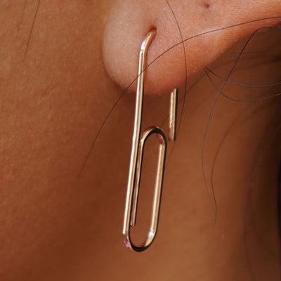 Close up view of a model's ear wearing a yellow gold Not A Paper Clip Earring