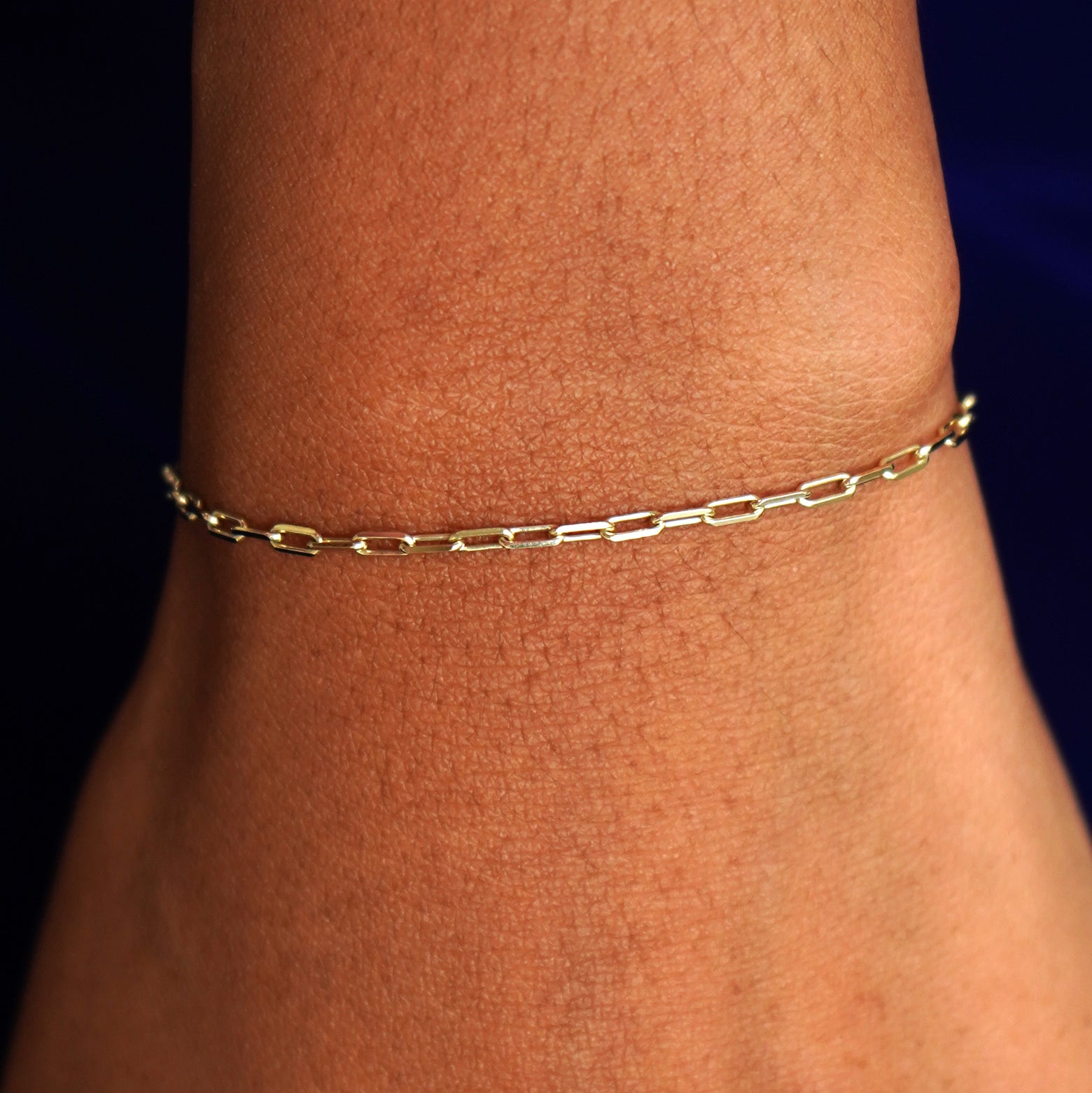 A model's wrist wearing a solid yellow gold Butch Bracelet