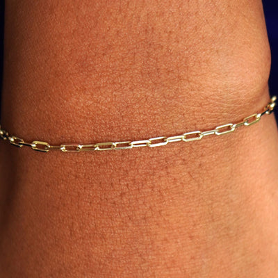 Close up view of a model's wrist wearing a solid yellow gold Butch Bracelet