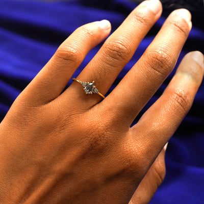 Close up view of a model's hand wearing a yellow gold Pear Salt and Pepper Diamond Ring on their finger