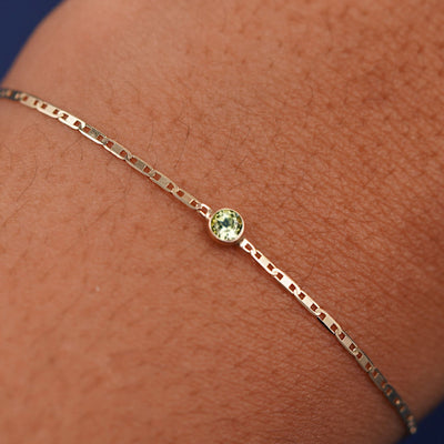 Close up view of a models wrist wearing 14k yellow gold Peridot Bracelet