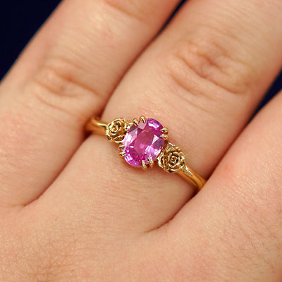 Close up view of a model's hand wearing a 14k yellow gold Green Diamond Leaves Ring