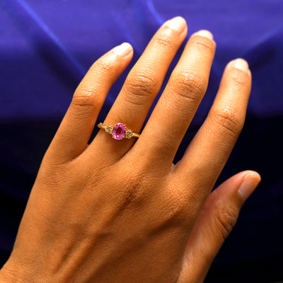 Close up view of a model's hand wearing a yellow gold Pink Sapphire Roses Ring
